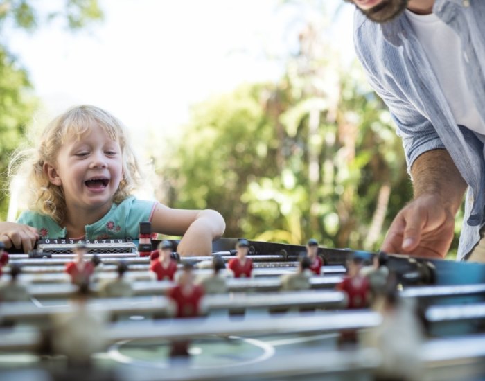 Child playing table football at villa with games facilities