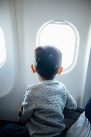Boy on aeroplane looking out of window