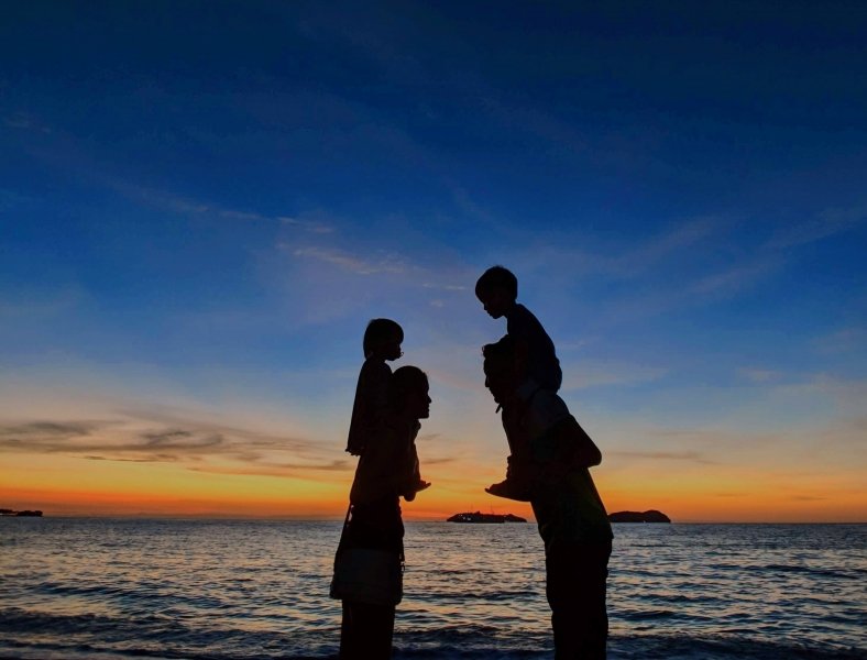 Family on beach at sunset