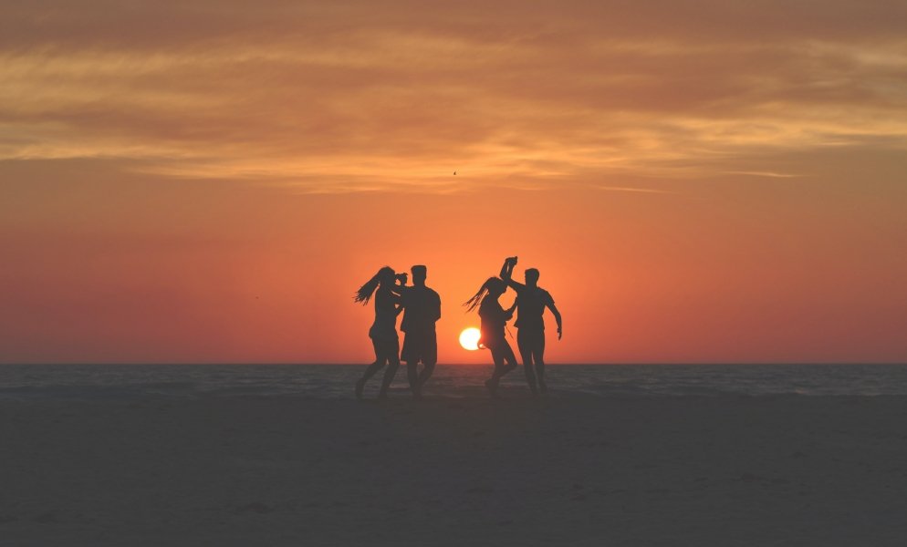 Friends on beach at sunset