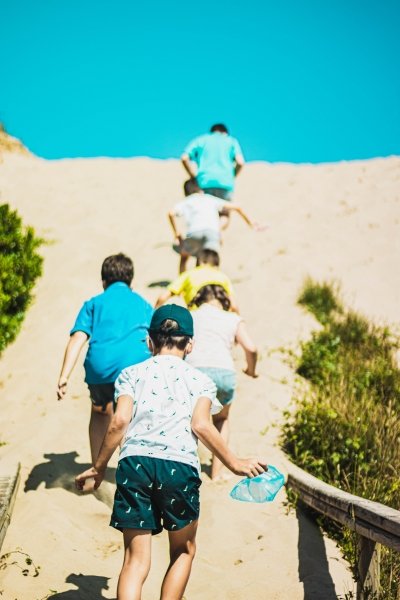 Family climbing up sand dunes, Spain
